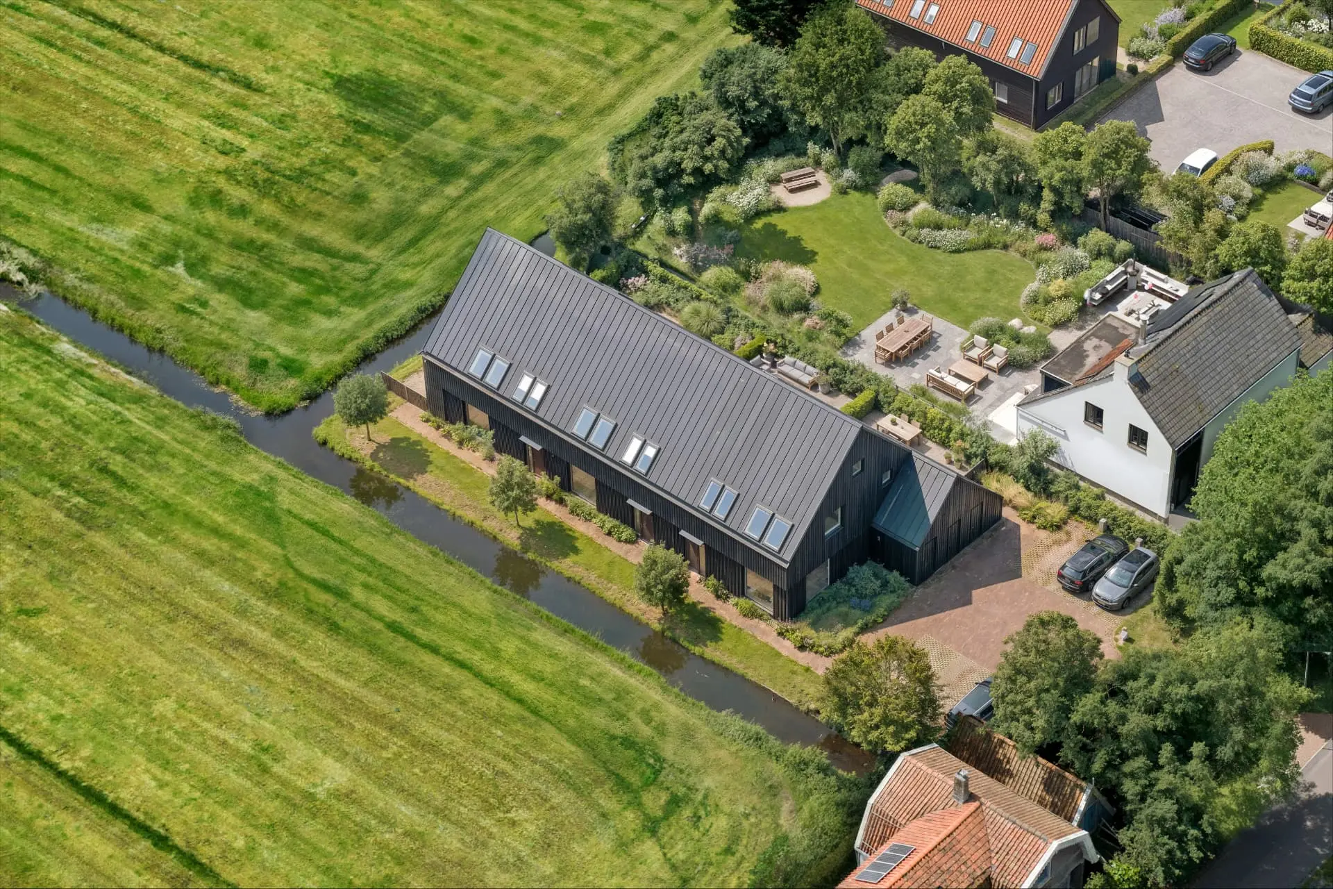 Luchtfoto van 16C Weidezicht met water, tuin en omliggende woningen